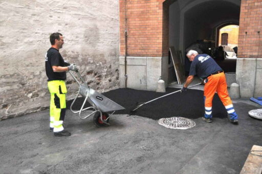 Asfaltarbeid i portrom med to arbeidere